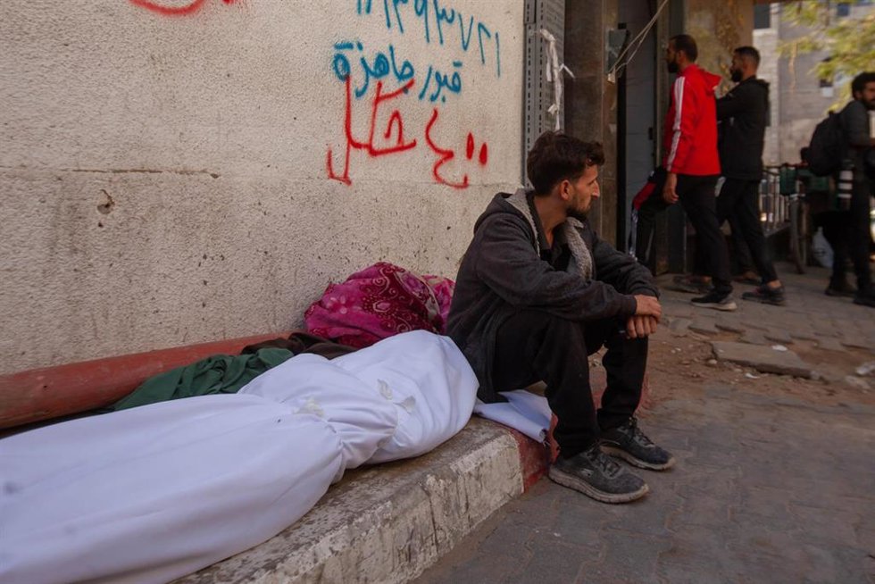 Un palestino junto al cadáver de una persona por un ataque del Ejército de Israel contra la Franja de Gaza a pesar del alto el fuego en vigor desde el 10 de octubre de 2025 (archivo)