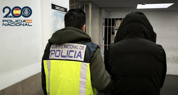 Un agente de la Policía Nacional con uno de los detenidos.