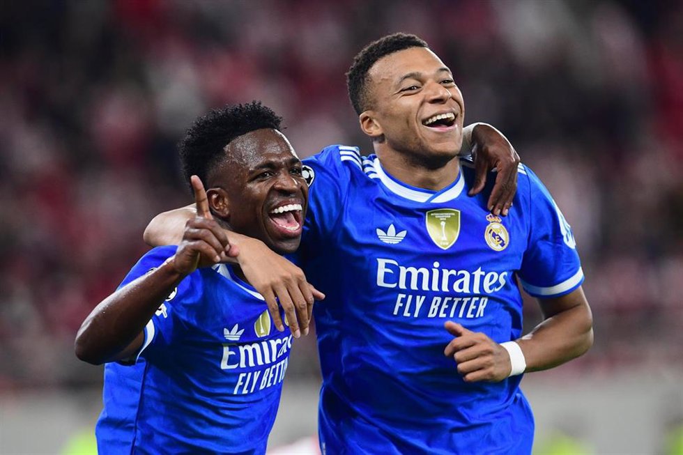 Los jugadores del Real Madrid Kylian Mbappe y Vinicius Júnior celebran uno de los tantos contra Olympiacos en Atenas en partido de la Liga de Campeones 2025-26.