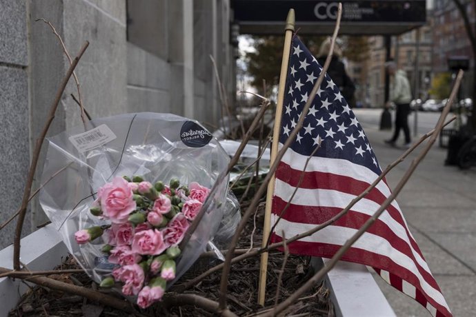 Un pequeño altar conmemorativo con flores y una bandera estadounidense frente a la estación de metro Farragut West en Washington DC en honor a los dos miembros de la Guardia Nacional de Virginia Occidental tiroteados, a escasa distancia de la Casa Blanca