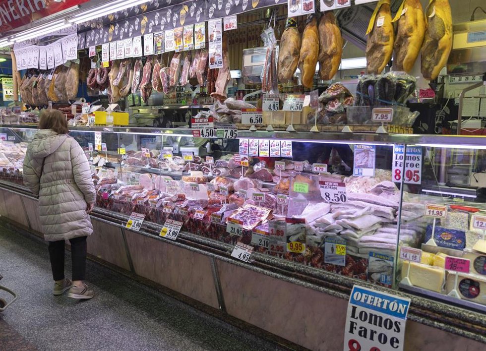 Archivo - Una mujer compra en una charcutería en un mercado, a 15 de marzo de 2023, en Madrid (España).