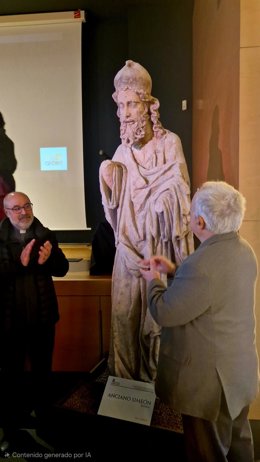 El consejero de  Cultura, Turismo y Deporte, Gonzalo Santonja (derecha) y el Cabildo Catedralicio, Florentino Alonso (izquierda), ante la réplica de la escultura del Anciano Simeón, unas de las 23 que se desmontaron del pórtico de la Catedral de León.