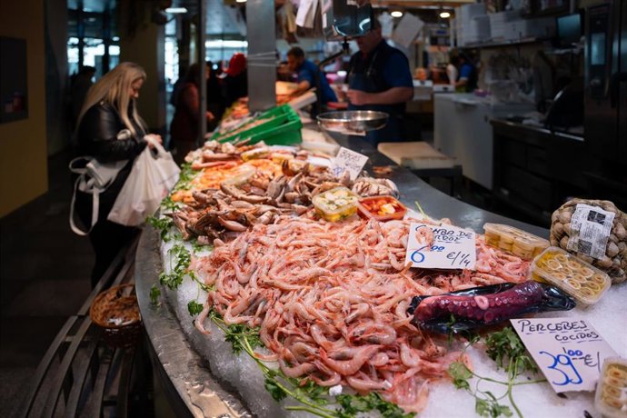 Archivo - Varias personas en el mercado de abastos realizan sus comprar el día previo a la cena de Nochebuena. A 23 de diciembre de 2024, en Sevilla (Andalucía, España). 