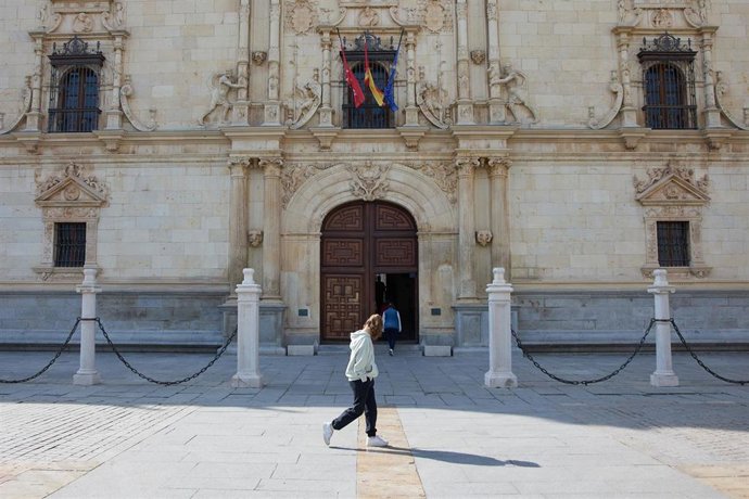 Archivo - Una transeúnte frente a la Puerta principal de la Universidad de Alcalá,.