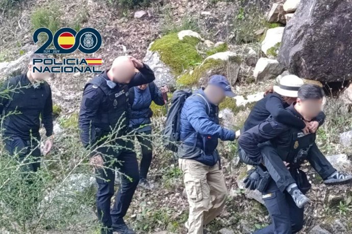 Agentes de la Policía Nacional de la Comisaría Local de Algeciras (Cádiz) cargando a la senderista accidentada en el Arroyo de la Miel.