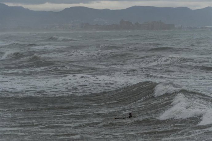 Archivo - Un hombre surfea junto al Puerto de Valencia, a 13 de noviembre de 2024, en Valencia, Comunidad Valenciana (España).