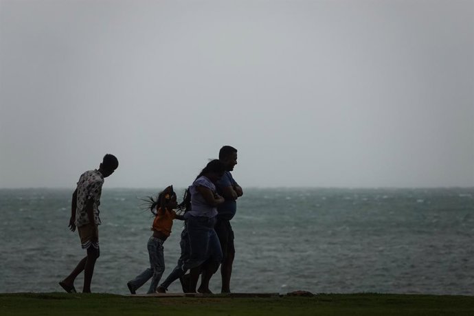COLOMBO, Nov. 27, 2025  -- A family walks through strong winds in Colombo, Sri Lanka, Nov. 27, 2025. Sri Lanka is confronting one of its most severe weather disasters in recent years, as days of heavy rainfall and multiple landslides have killed 31 people