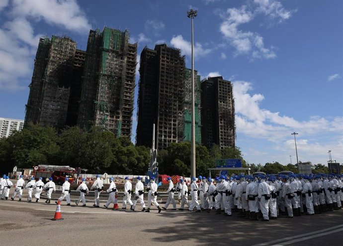 La Unidad de Identificación de Víctimas de la Policía de Hong Kong, desplegada ante los restos calcinados del complejo residencial Wang Fuk 