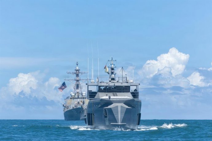 22 de novembro de 2025, Mar do Caribe, águas internacionais: O destróier de mísseis guiados classe Arleigh Burke da Marinha dos EUA USS Winston S. Churchill, à esquerda, patrulha com o navio-patrulha classe Defiant da Força de Defesa da Guiana GDFS Shahou