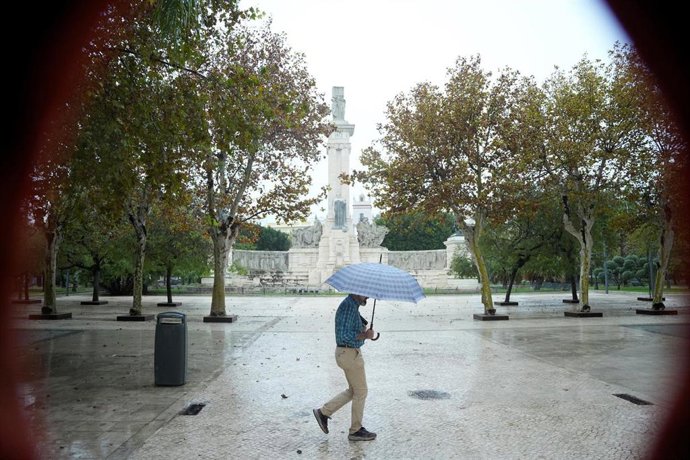 Archivo - Imagen de archivo de un transeunte bajo sus paraguas durante la intensa lluvia. A 11 de octubre de 2024, en Cádiz (Andalucía, España).