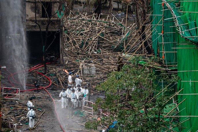30 de novembro de 2025, Hong Kong, Hong Kong: Policiais carregam um corpo recuperado de um bloco de apartamentos danificado pelo fogo no complexo habitacional Wang Fuk Court, em Tai Po, após um incêndio mortal em 30 de novembro de 2025, em Hong Kong.