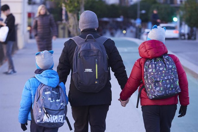 Archivo - Un padre, con sus dos hijos, caminan abrigados con la llegada de la borrasca Gerard, a 16 de enero de 2023 en Sevilla (Andalucía, España).