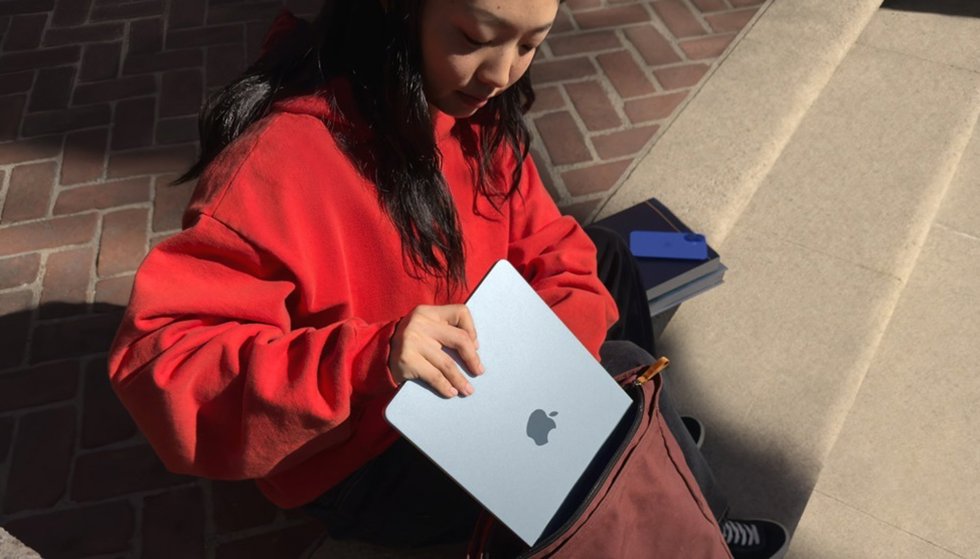 Mujer guardando en la mochila un MacBook Air