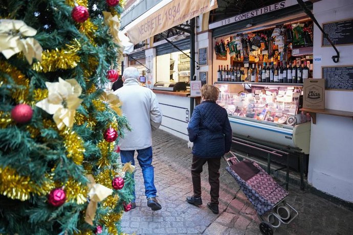 Archivo - Varias personas en el mercado  comprando en Navidad