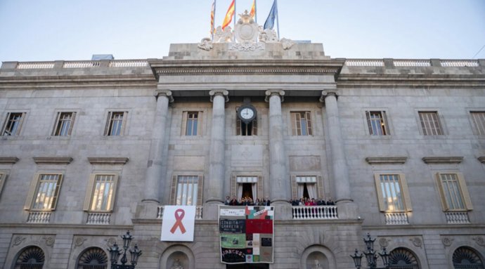 Barcelona despliega el Tapiz Memorial del Sida desde el balcón del Ayuntamiento