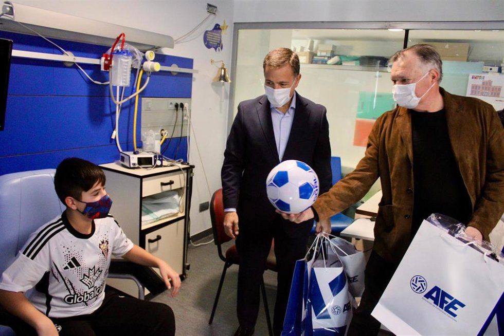 El exfutbolista José Antonio Camacho y el alcalde de Albacete, Manuel Serrano, visitando a un niño en el hospital de Albacete.