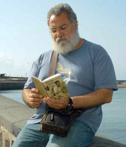 El escritor Antonio Félix Martín Hormiga, junto a uno de sus libros en la boca del muelle, en Arrecife