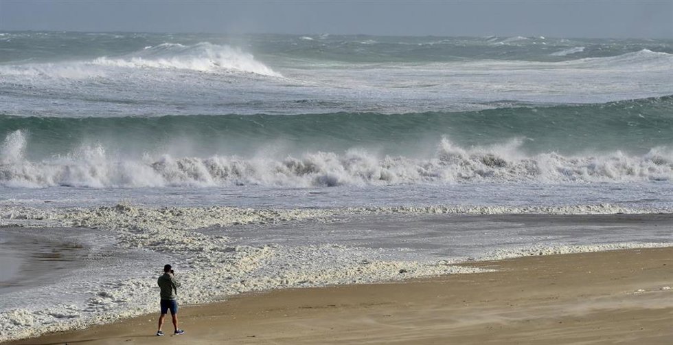 Archivo - Una persona hace fotos del oleaje en Santander