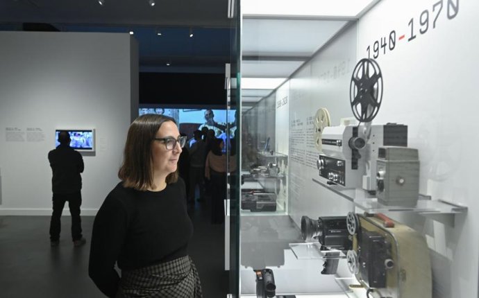 Una mujer observa una cámara expuesta.