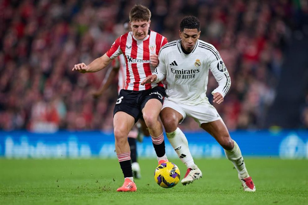Archivo - El centrocampista español Mikel Jaureguizar (Athletic Club) intenta robar el balón al inglés Jude Bellingham (Real Madrid), en el partido de LaLiga EA Sports 2024-25 disputado en San Mamés.
