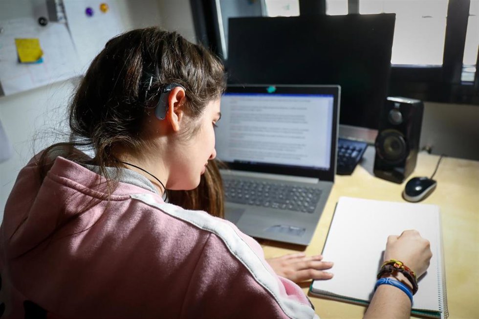 Archivo - Rosalía, una joven con audífono, estudiando.