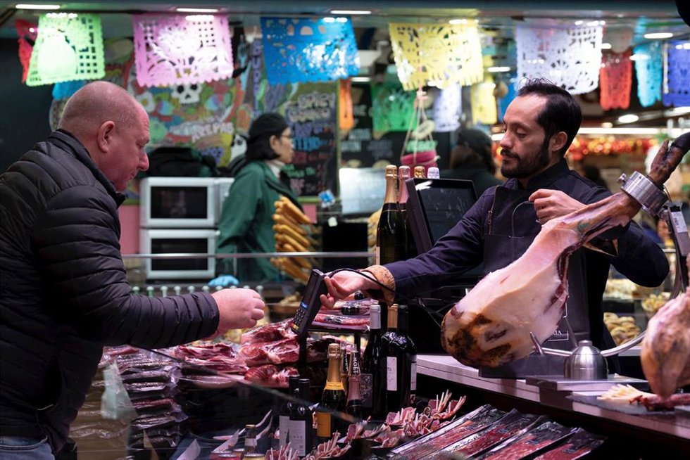 Archivo - Un comerciante cobra a un cliente, en el Mercado de la Boquería, a 14 de diciembre de 2023, en Barcelona, Catalunya (España)