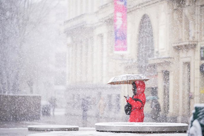 Archivo - Una persona sujeta un paraguas al caminar por una de las calles de Vitoria-Gasteiz tras la intensa nevada caída sobre la ciudad, a 27 de febrero de 2023, en Vitoria-Gasteiz, Álava, Euskadi (España). 