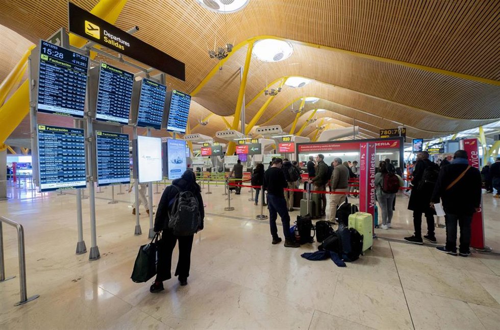 Archivo - Varias personas observan las salidas de los vuelos en el Aeropuerto Adolfo Suárez-Madrid Barajas