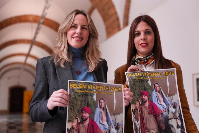 La responsable de Cultura de la Diputación, Vanesa Beltrán (i), y la alcaldesa de Espera, Tamara Lozano (d), con los carteles del tradicional Belén Viviente de Espera, que se representará el 20 de diciembre.