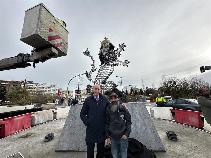 El alcalde de León, José Antonio Diez (izquierda) y el escultor Fernando Ortiz supervisan la instalación de la escultura del 'León rampante' en la glorieta del Puente de Los Leones de la capital leonesa.