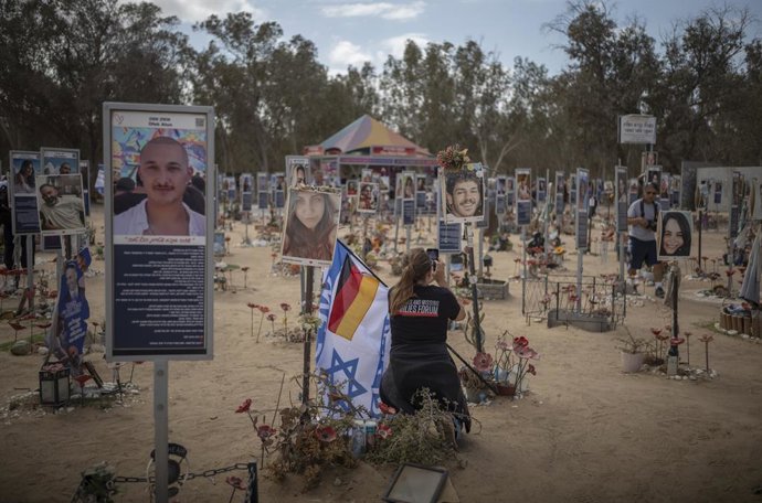 Archivo - Arquivo - 06 de outubro de 2025, Israel, Re'im: Uma mulher segurando um Irsaeli e um glaf alemão tira uma foto no local do festival Nova em Re'im antes do aniversário de dois anos do ataque liderado pelo Hamas em 7 de outubro. Foto: Ilia Yefimov
