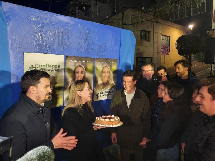 La candidata del PP a la reelección como presidenta de la Junta, María Guardiola, en la pegada de carteles con una tarta regalada por asistentes al acto con motivo de la celebración de su cumpleaños
