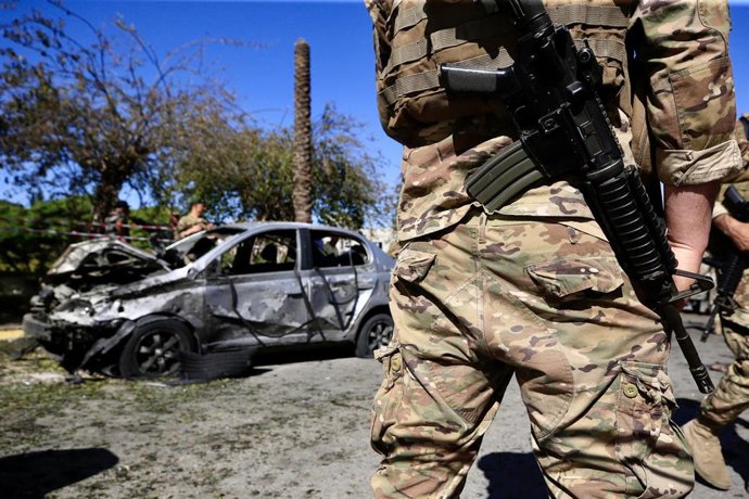 Archivo - Soldado del Ejército libanés junto a un vehículo calcinado fruto de una explosión 