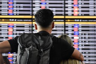 Archivo - Una pareja observa los paneles de información de vuelos en el Aeropuerto Internacional El Dorado de Bogotá, Colombia