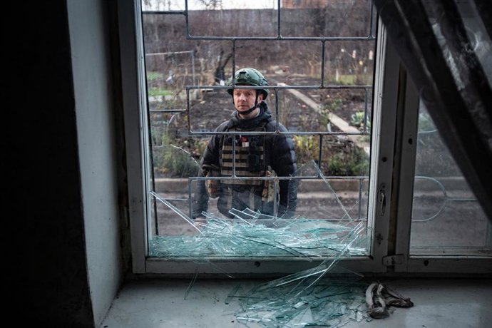 Imagem de arquivo de um militar em frente a uma janela danificada por um ataque na Ucrânia.