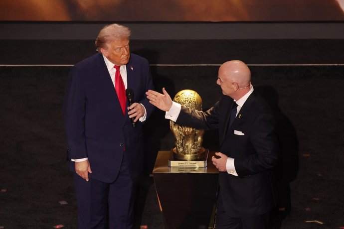 04 December 2025, US, Washington: US President Donald Trump is presented with the inaugural FIFA Peace Prize award by FIFA President Gianni Infantino during the 2026 FIFA World Cup draw at the John F. Kennedy Center for the Performing Arts in Washington. 