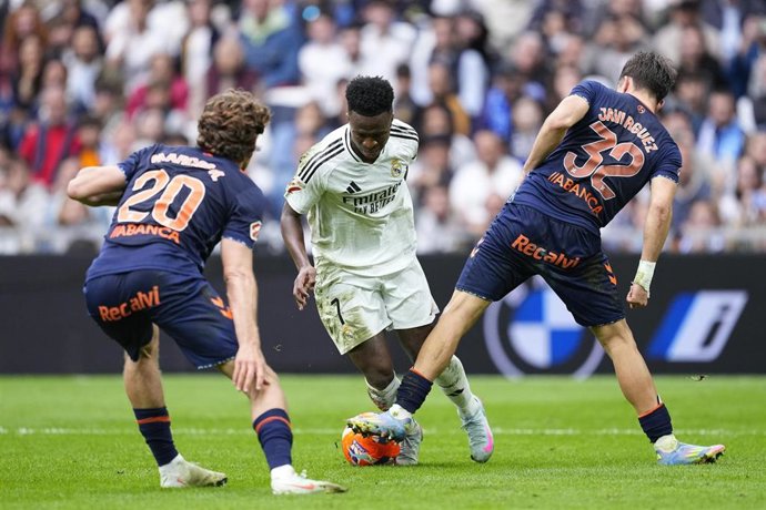 Archivo - El delantero brasileño Vinícius Júnior (Real Madrid) intenta regatear a Javi Rodríguez y Marcos Alonso (RC Celta), en el partido de LaLiga EA Sports 2024-25 disputado en el Santiago Bernabéu.