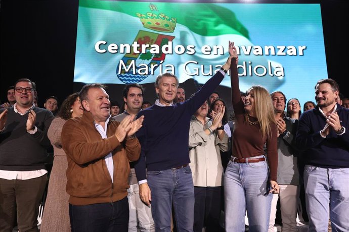 O Presidente do PP, Alberto Núñez Feijóo (c), a Presidente do PP de Extremadura, María Guardiola (d), e o Prefeito de Lobón, Roberto Romero (l), participam de um evento público no Pavilhão Municipal Juan de Dios Ordóñez, em 16 de novembro de 2025,