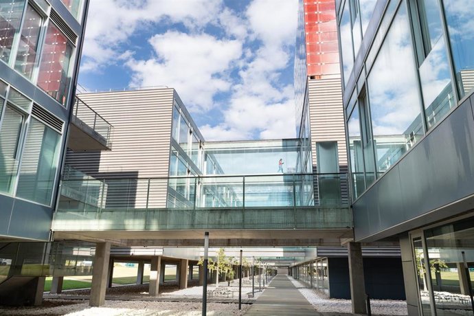 Vista de pasajes acristalados entre edificios con mujer andando. CPI, Ciudad Politécnica de la Innovación. Parque científico.