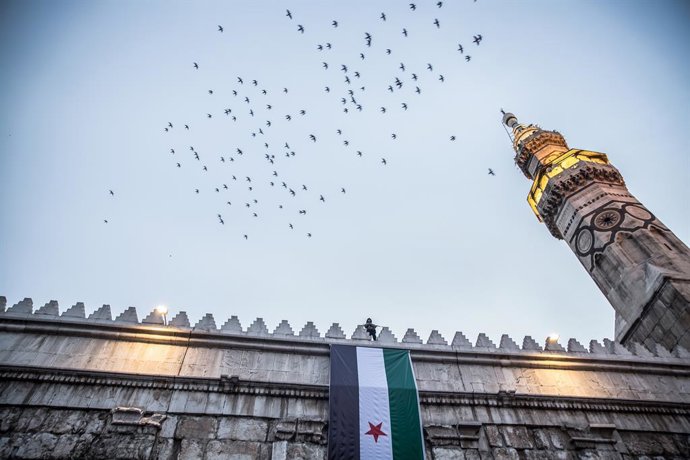 9 de dezembro de 2025, Damasco, Síria: Um membro armado das forças de segurança da Síria monta guarda no topo da Mesquita Umayyad, em Damasco, na manhã do primeiro aniversário da queda do regime de Assad. Bashar al-Assad e seu pai Hafez governaram a Síria