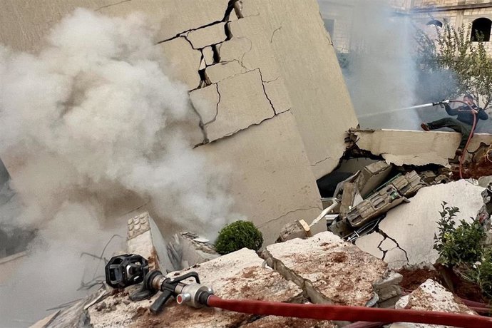 Archivo - Un bombero intenta extinguir el fuego en un edificio destruido por los ataques aéreos israelíes en la ciudad de Yabaa, en el sur del Líbano