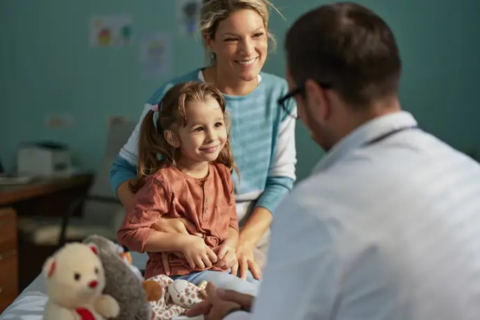 Niña en la consulta del médico acompañada de su madre.