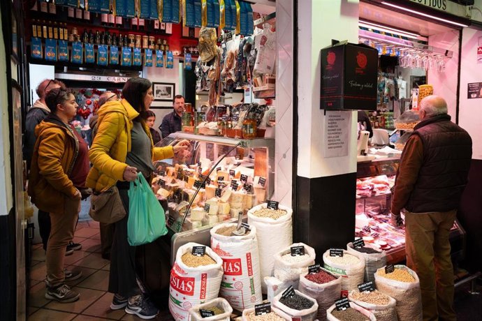 Archivo - Varias personas en el mercado de abastos comprando para Navidad