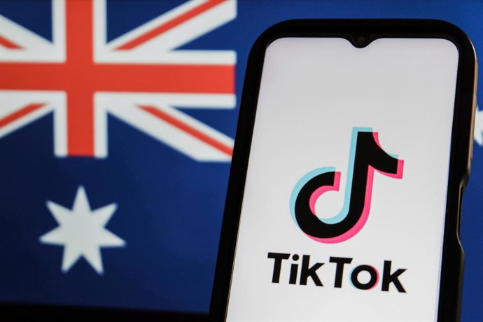 8 de dezembro de 2025, Indonésia: Nesta ilustração fotográfica, o logotipo do TikTok é exibido em uma tela de telefone com a bandeira australiana em segundo plano. A Lei de Alteração da Segurança Online (Idade Mínima de Mídia Social) de 2024 exige que as 