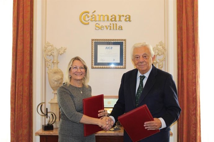 La delegada estatal para la Zona Franca de Sevilla, Carmen Tovar, y el presidente de la Cámara de Comercio de Sevilla, Francisco Herrero, firman un acuerdo.