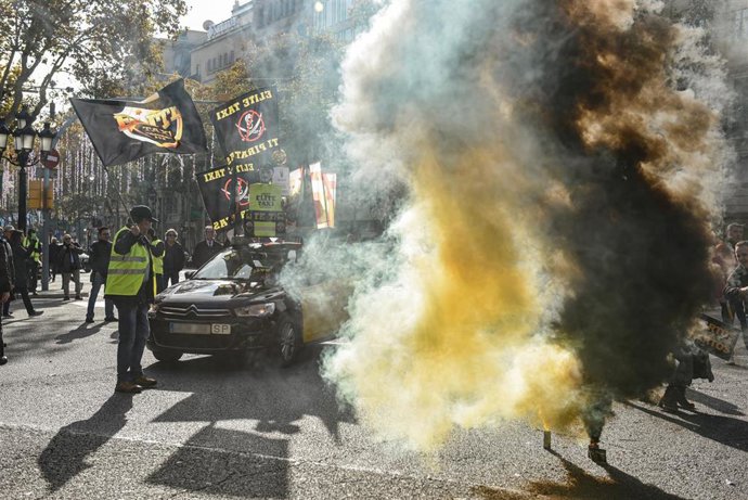 Varios manifestantes con bombas de humo durante una marcha lenta, a 9 de diciembre de 2025, en Barcelona, Catalunya (España)