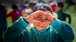 Un niño forma un corazón con sus manos, en una imagen de la campaña de Navidad de Entreculturas.