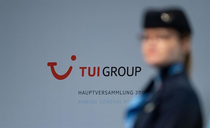Archivo - FILED - 12 February 2019, Lower Saxony, Hannover: A Tui stewardess stands in front of the company logo at the Annual General Meeting of Tui AG. 