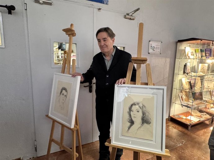 Luis García Montero posa junto a dos retratos del legado literario donado a la Universidad de Granada.