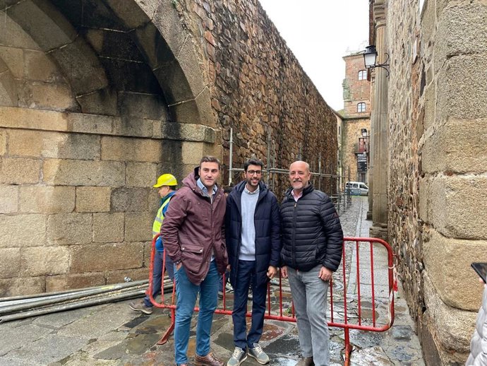 El concejal de Urbanismo y Patrimonio Histórico, Tirso Leal;  el concejal de Turismo, Ángel Orgaz, y el de Cultura, Jorge Suárez, en la muralla de Cáceres tras el comienzo de las obras de restauración de un nuevo tramo
